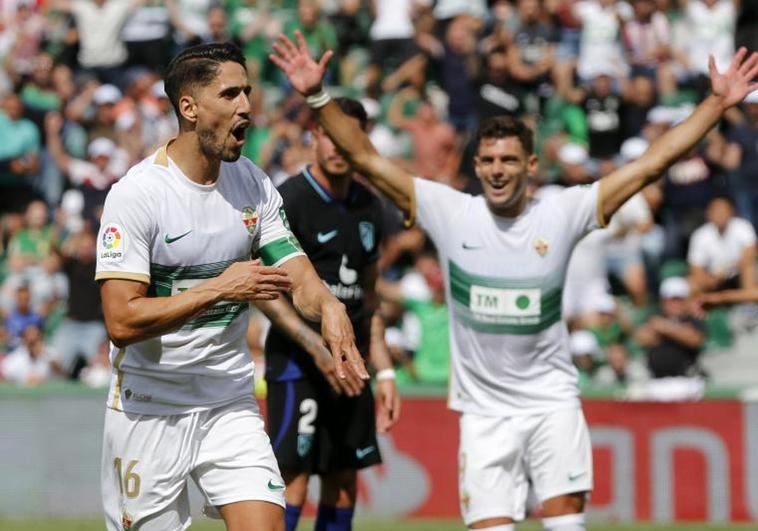 El delantero del Elche Fidel Chaves de la Torre (i) celebra su gol marcado ante el Atlético de Madrid.