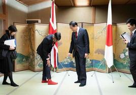 Insólita imagen en la que el primer ministro británico, Rishi Sunak, muestra sus calcetines con el logo del club de béisbol Hiroshima Toyo Carp. a su homólogo japonés, Fumio Kishida, seguidor de este equipo