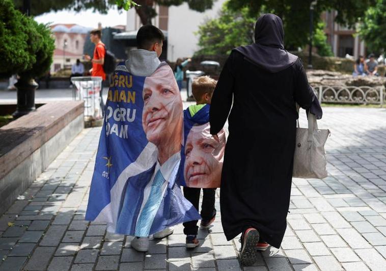 Una familia camina por el centro de Estambul enfundados en las banderas electorales de Erdogan.