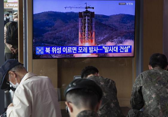 Varias personas ven las noticias ​​en Seúl sobre que Corea del Norte lanzará un satélite espía militar a principios de junio