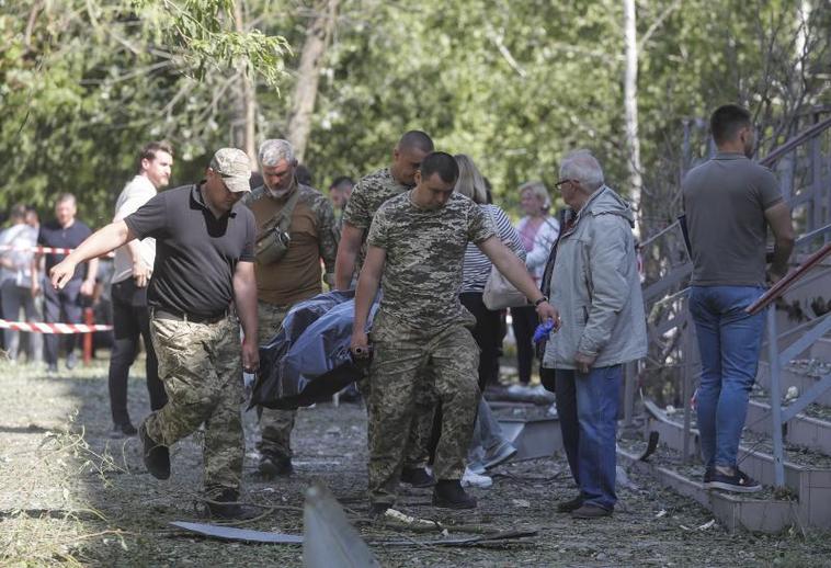 Un equipo forense traslada el cadáver de una de las dos mujeres fallecidas el jueves en Kiev tras la caída de un misil.