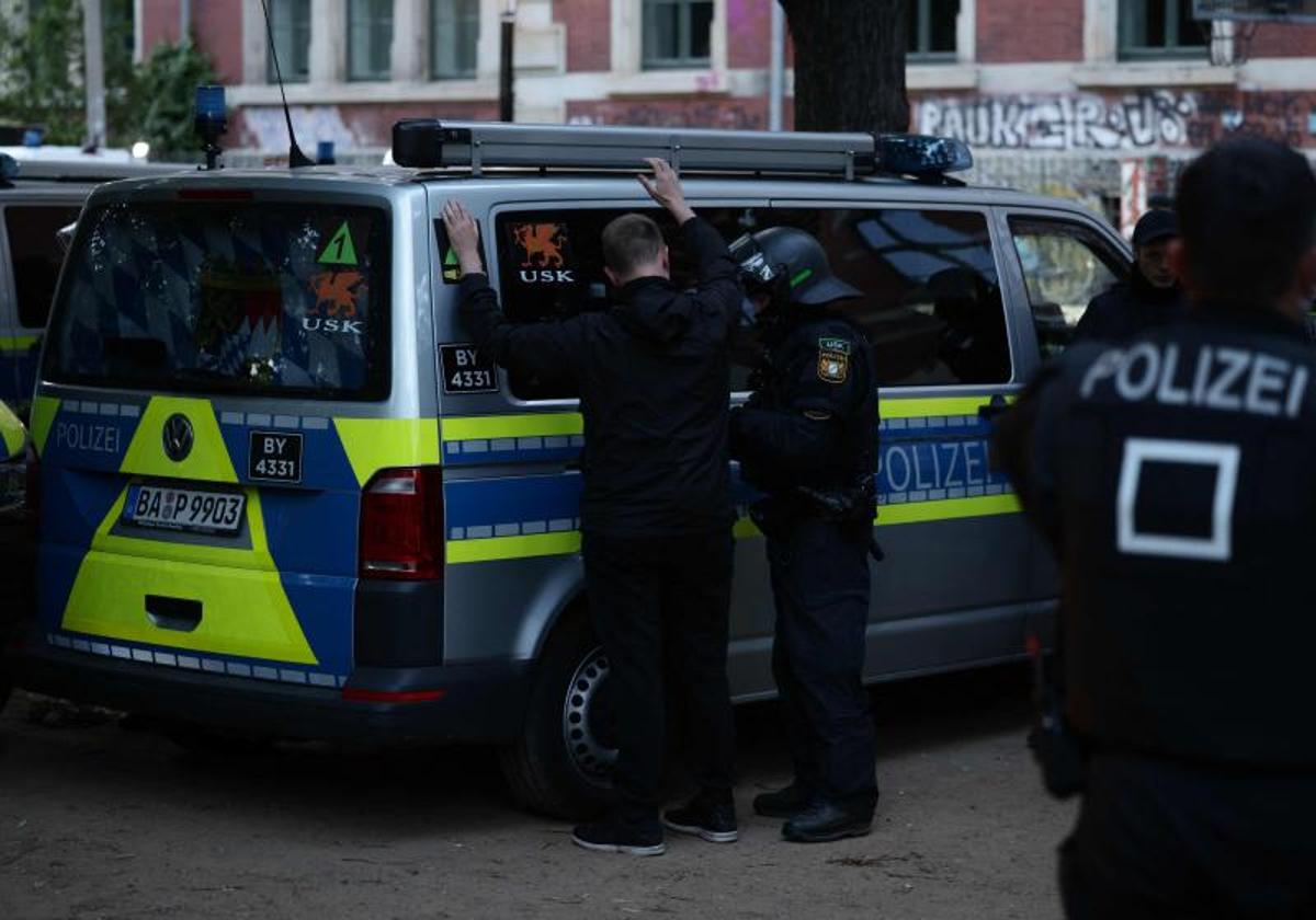 Un agente antidisturbios procede a la detención de uno de los radicales.