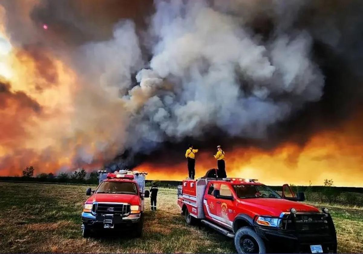 Bomberos canadienses rodeados por un gigantesco fuego en Fort St John, Columbia Británica.