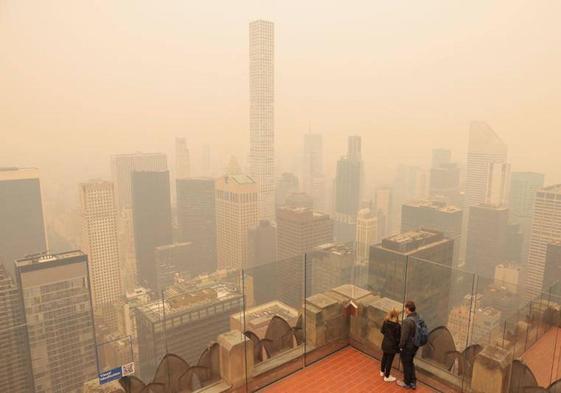 Un hombre corre envuelto por el humo en Washington D.C., donde apenas se divisaba este jueves el Capitolio.