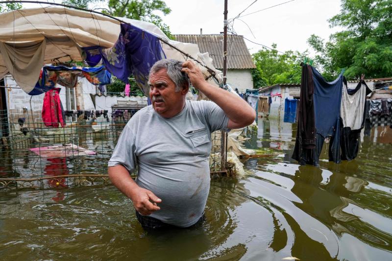 Un residente local camina por el patio inundado de su casa en Afanasivka.