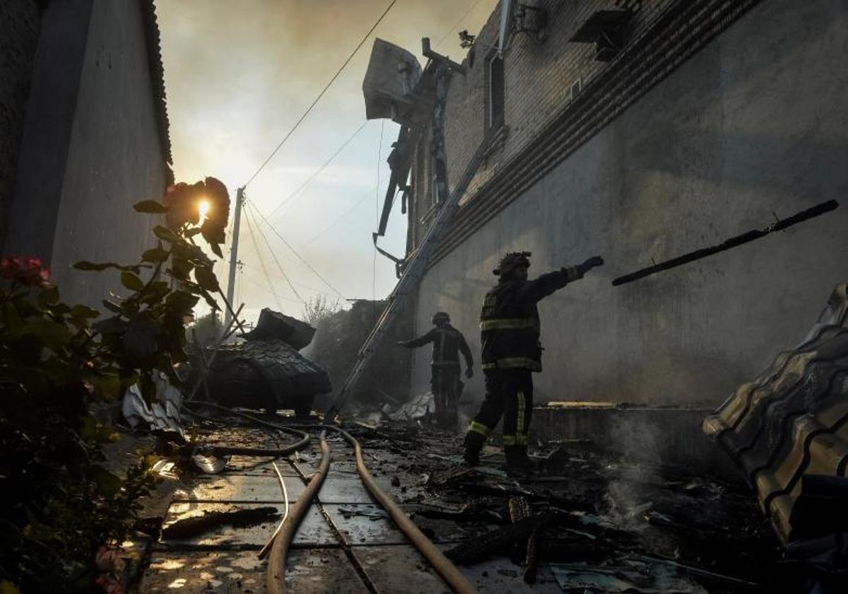 Rescatistas observan los destrozos causados por un bombardeo ruso en Jersón.