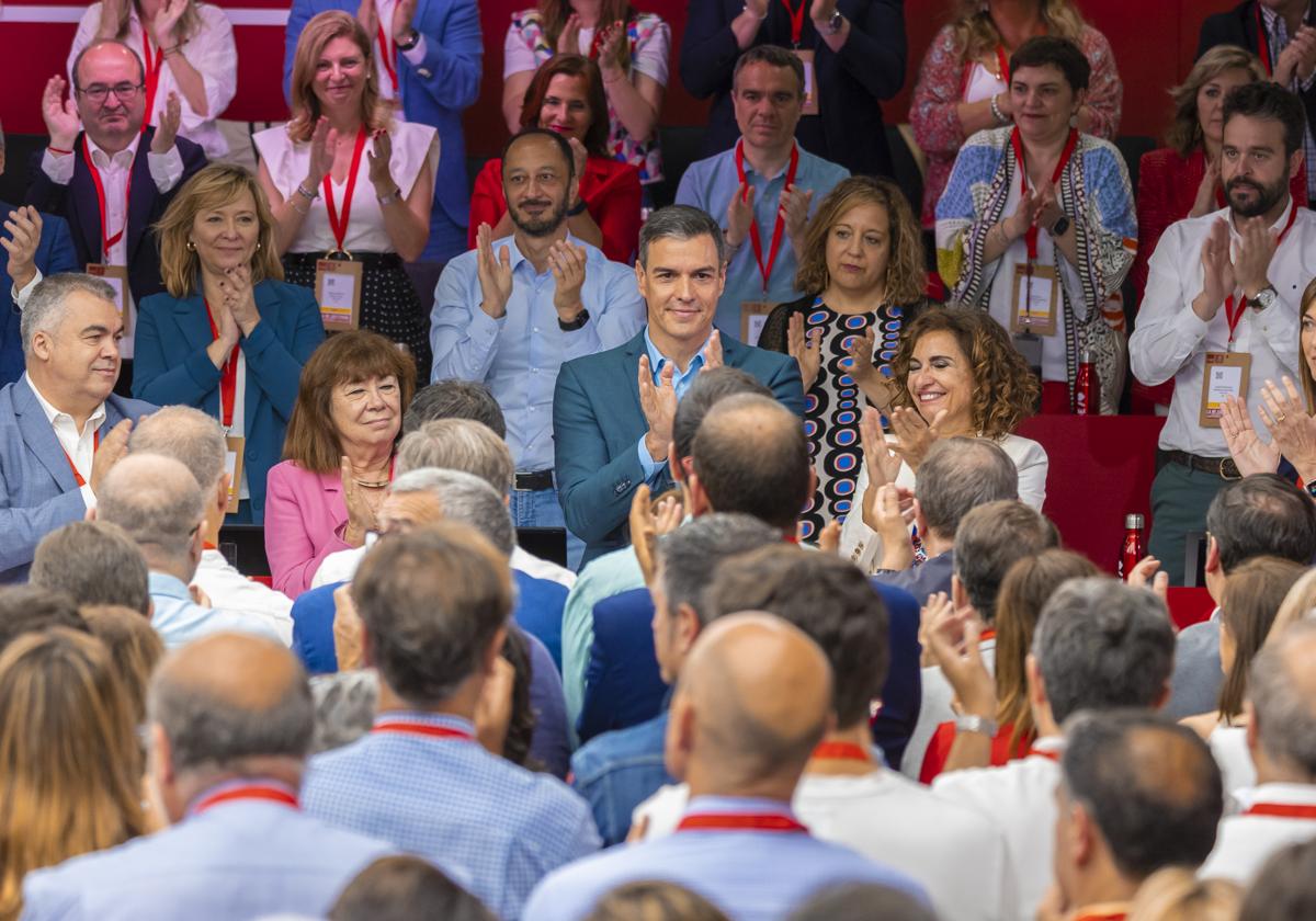 Los asistentes al comité federal, muchos con la inquietud pintada en el rostro, aplauden a Sánchez.