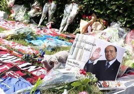 Un hombre coloca flores afuera de Villa San Martino, la residencia del ex primer ministro italiano Silvio Berlusconi, luego de su muerte