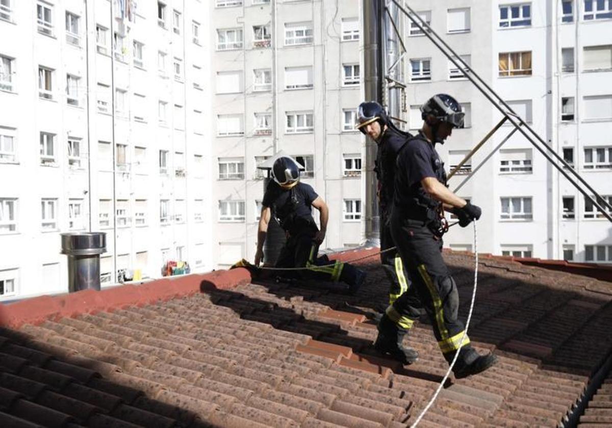 Los bomberos se preparan para descolgarse desde el tejado del edificio de la calle Fundición.