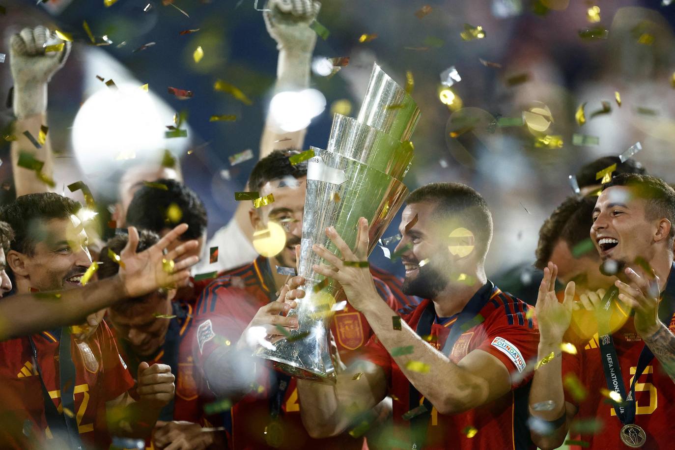 El defensa español Nacho Fernández (centro) sostiene la Copa de la Liga de Naciones de la UEFA mientras los jugadores españoles celebran en el podio después de ganar la tanda de penaltis y el partido de fútbol final de la Liga de Naciones de la UEFA entre Croacia y España en el Estadio De Kuip en Rotterdam, el 18 de junio de 2023.