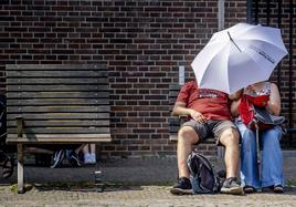 Hombre y mujer bajo paraguas en Ámsterdam.