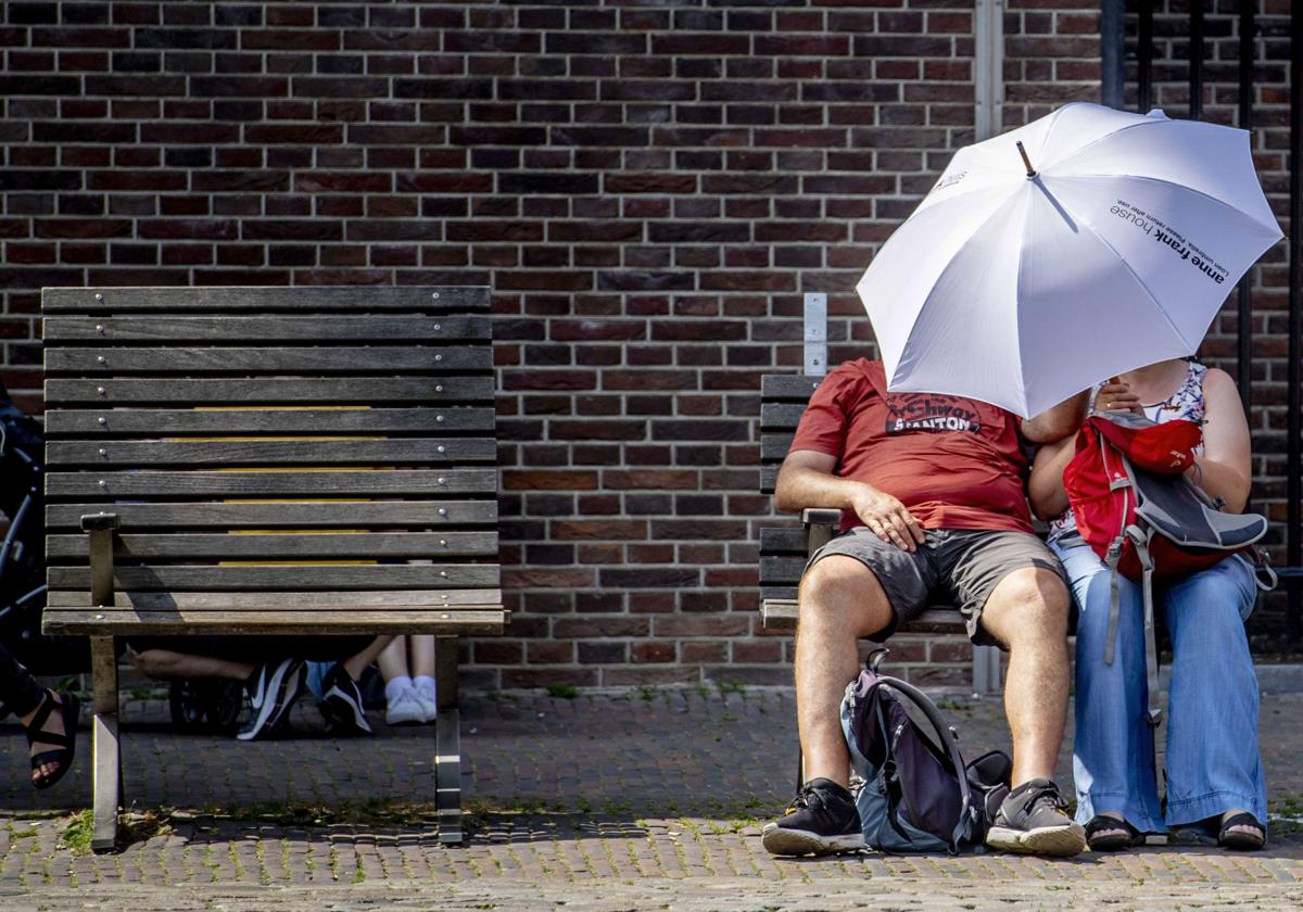 Hombre y mujer bajo paraguas en Ámsterdam.