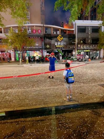 Un niño observa el edificio carbonizado, a la derecha, desde una calle sembrada de vidrios expulsados por la explosión.