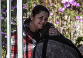 Dos personas se abrazan en la entrada a la escuela Profesora Helena Kolody, donde dos jóvenes fueron asesinados por un exalumno, en Brasil