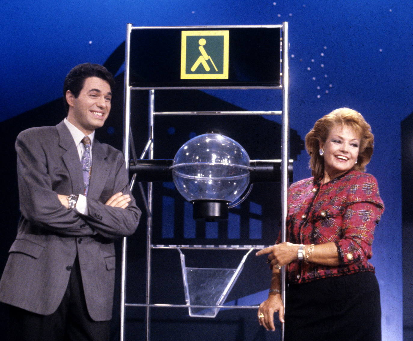 El presentador Agustín Bravo junto a Carmen Sevilla en 1991, durante una emisión del programa en directo 'El Telecupón', que se emitía diariamente en la cadena privada Tele 5.