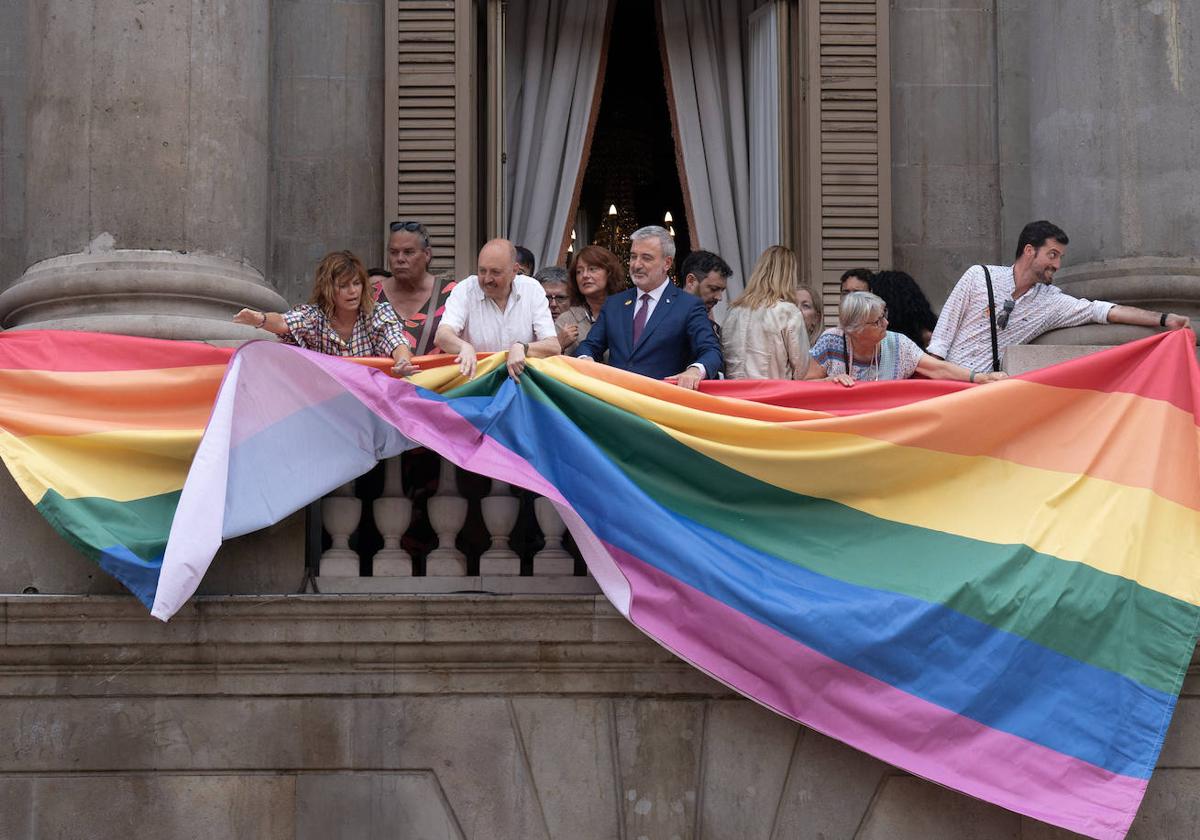 El alcalde Jaume Collboni cuelga la bandera arcoíris en la fachada del Ayuntamiento de Barcelona.