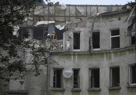 Los bomberos buscan posibles víctimas entre los restos de uno de los edificios atacados.