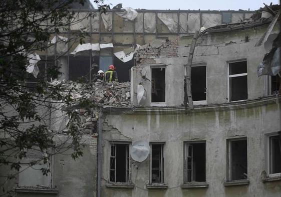 Los bomberos buscan posibles víctimas entre los restos de uno de los edificios atacados.