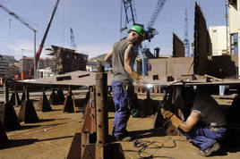 Dos trabajadores en un astillero.