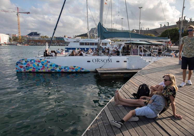 Turistas se disponen a partir a una excursión por las aguas de la Ciudad Condal.