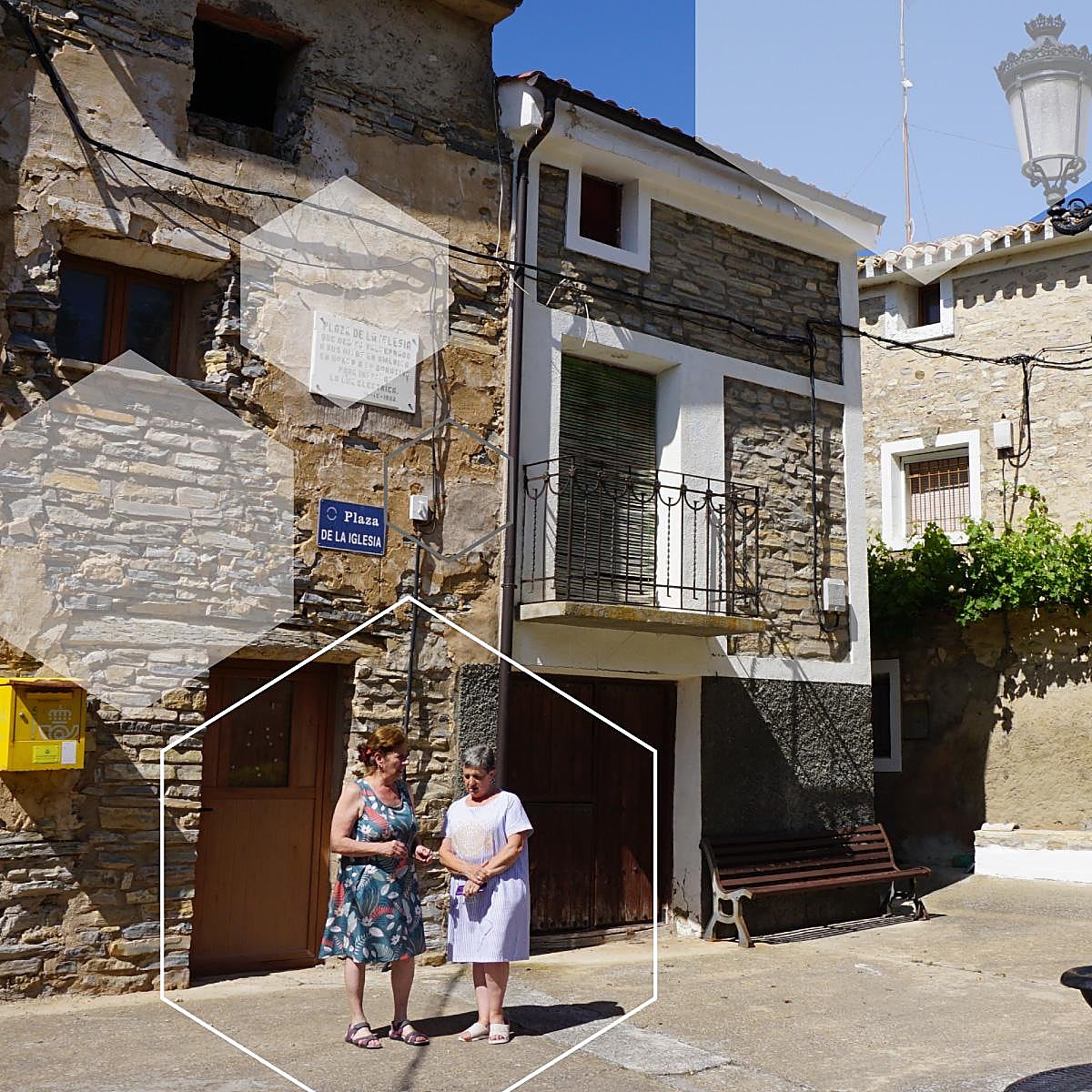 Dos vecinas conversan en la plaza de la iglesia de Valdeprado, donde un 85% del censo se encuentra fuera de España.