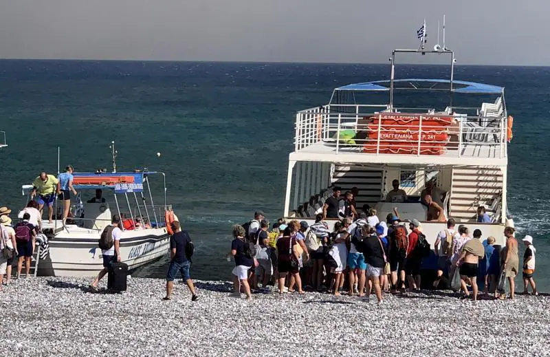 Bir grup turist deniz yoluyla plajdan tahliye ediliyor.