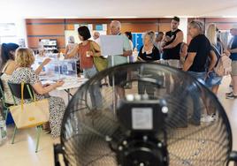 Votantes en un colegio electoral catalán en el que, como en otras localidades, se instalaron ventiladores para suavizar las altas temperaturas.