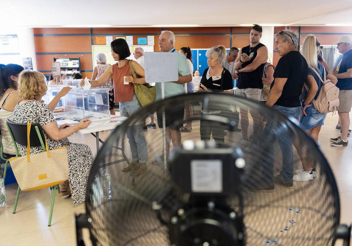 Votantes en un colegio electoral catalán en el que, como en otras localidades, se instalaron ventiladores para suavizar las altas temperaturas.