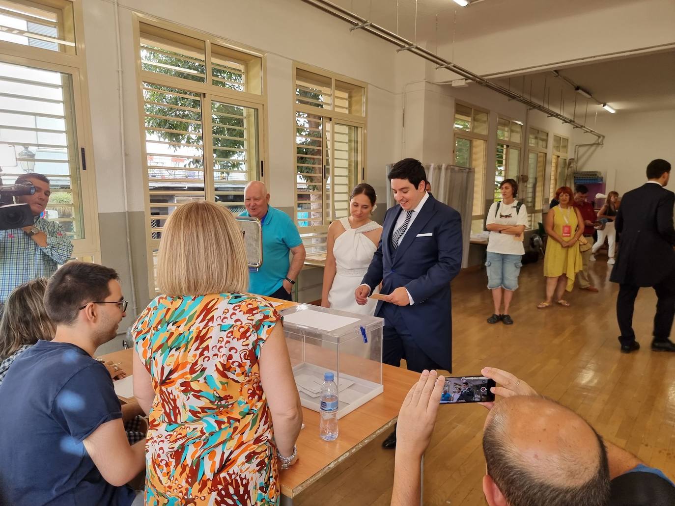 Pilar y Luis, una pareja casada ayer, han acudido a depositar su voto vestidos de novios y acompañados de amigos e invitados tras pasar la noche celebrando el enlace, en Granada.