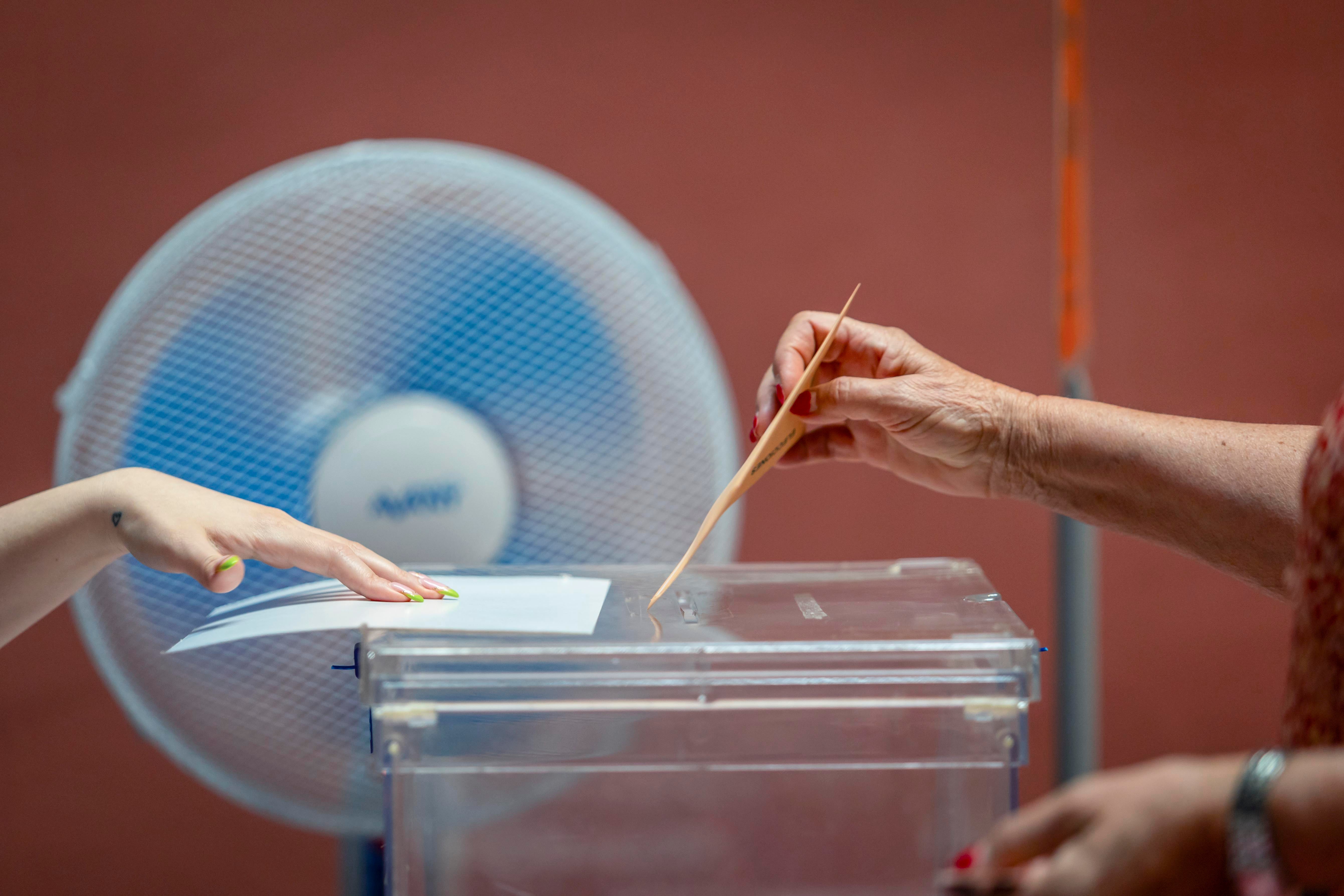 Una votante ejerce su derecho al voto en las elecciones generales ante un ventilador este domingo en el Teatro Rojas de Toledo.