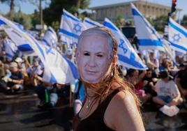Una mujer se manifiesta contra la reforma con una careta de Netanyahu.