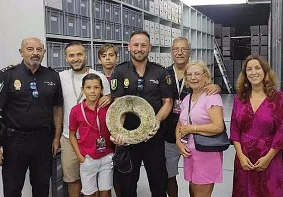 Imagen del niño, acompañado por su familia, con la piedra que halló.