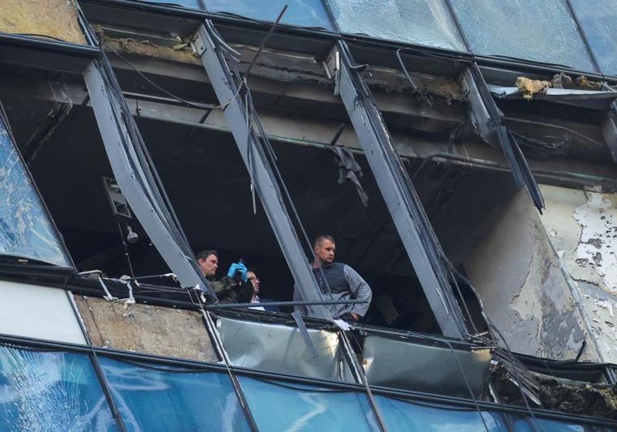 Tres policías examinan los daños causados por el dron en una torre de la City moscovita.