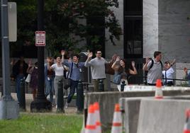 Un grupo de personas sale del edificio de oficinas del Senado con las manos en alto tras ser alertada la Policía sobre la posible presencia de un tirador.