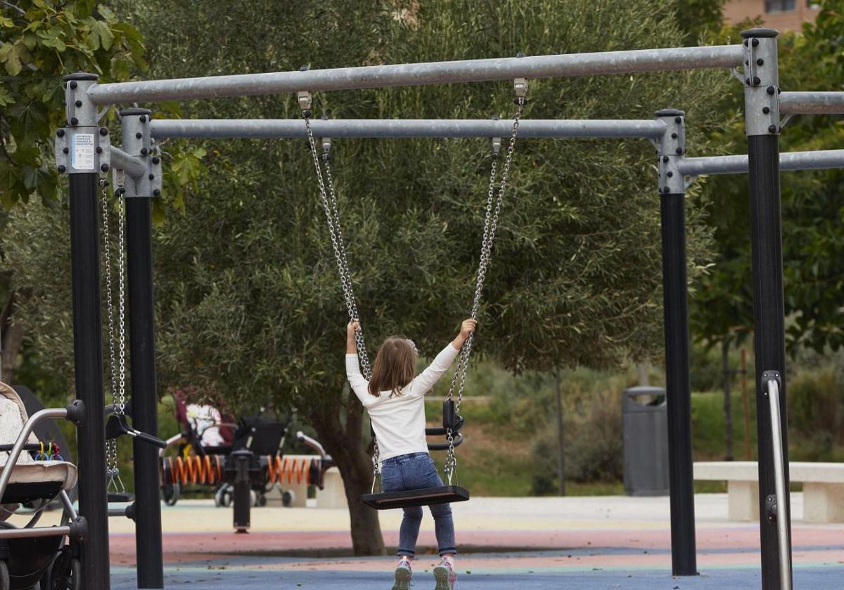 Una niña montada en un columpio.