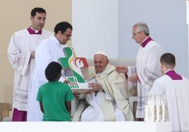 Varios asistentes a la Jornada Mundial de la Juventud celebrada estos días en Lisboa entregan una placa conmemorativa al papa Francisco.