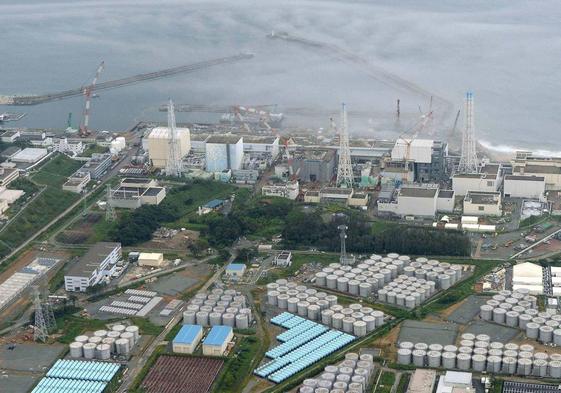 Vista aérea de la central nuclear de Fukushima y, abajo,los tanques de almacenamiento de agua contaminada años después del tsunami.