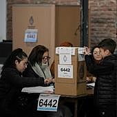 Un niño ayuda a su madre a votar en un colegio de Buenos Aires durante las elecciones primarias celebradas ayer en Argentina.