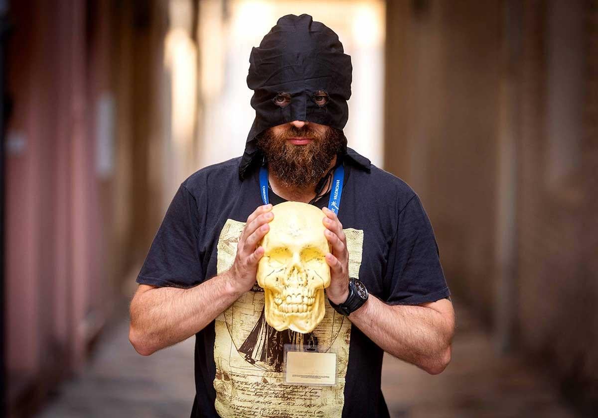 Alejandro Alapont, con su calavera 'Cayetano', en el callejón valenciano antes conocido como el 'de las brujas'.