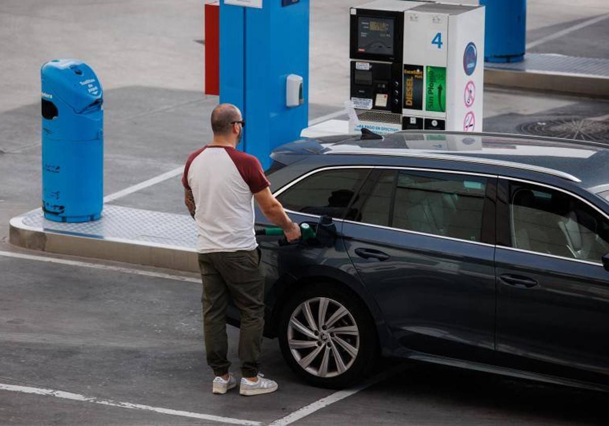 Un hombre reposta carburante en una gasolinera.