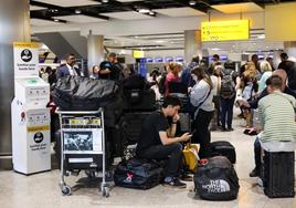 Viajeros afectados por el fallo técnico esperan cerca de la zona de facturación de British Airways en el aeropuerto de Heathrow.