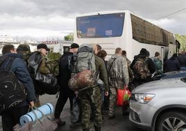 Varios hombres suben a un autobús en una oficina de reclutamiento durante la movilización militar parcial de Rusia