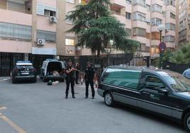 Agentes de la Policía Nacional junto al coche fúnebre en la avenida de Madrid.