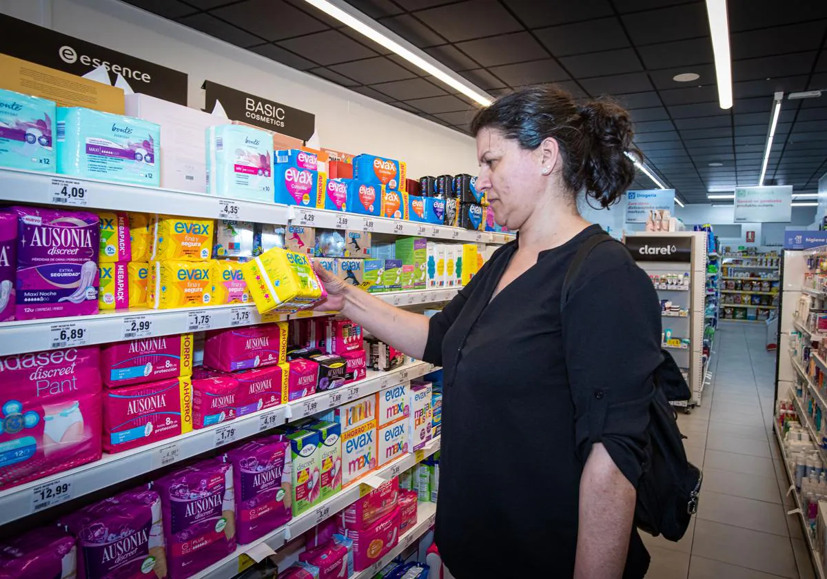 Una mujer compra productos menstruales en una tienda