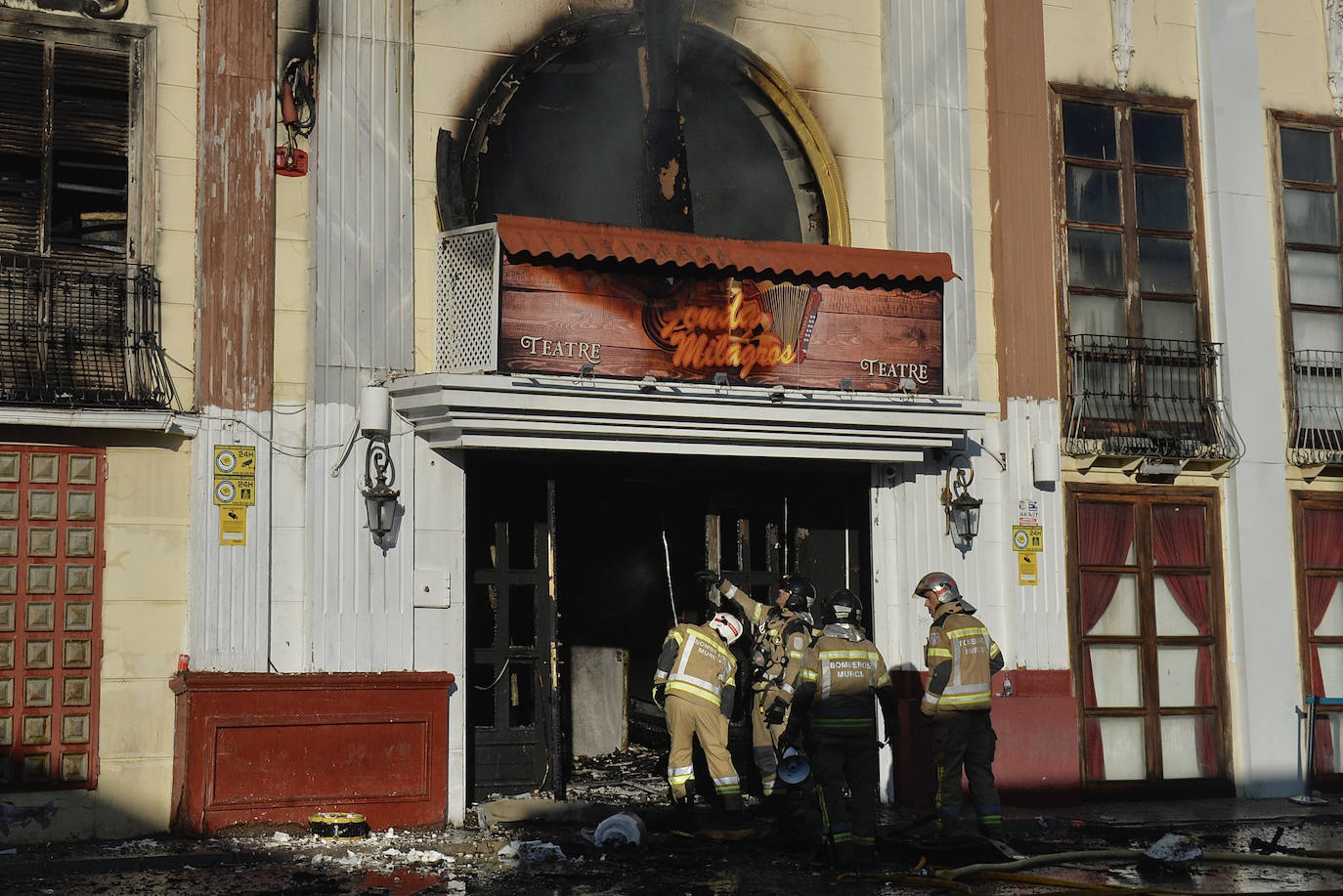 Varios bomberos trabajan en la puerta principal de la discoteca Teatre.