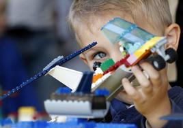 Niño juega con un avión montado con piezas en el Festival Lego, en Oslo.