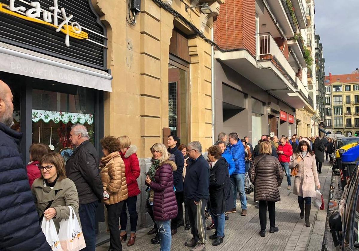 Decenas de personas hacen cola para comprar croquetas en Bilbao.