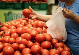 Una mujer usa una bolsa compostable en el supermercado.