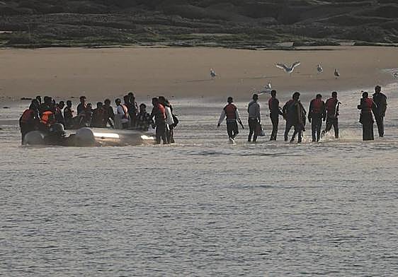 Un grupo de migrantes desembarca en la playa francesa de Le Portel después de un intento fallido de cruzar el Canal de la Mancha.