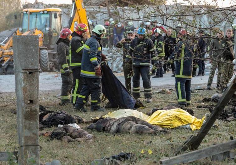 Equipos de rescate ucranianos acumulan los cadáveres hallados entre los cascotes del edificio bombardeado.